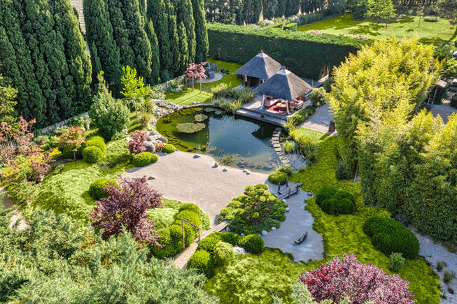 Vue aérienne du Jardin de la Méditation : bassin, îlots minéraux, paillotes, bambouseraie.