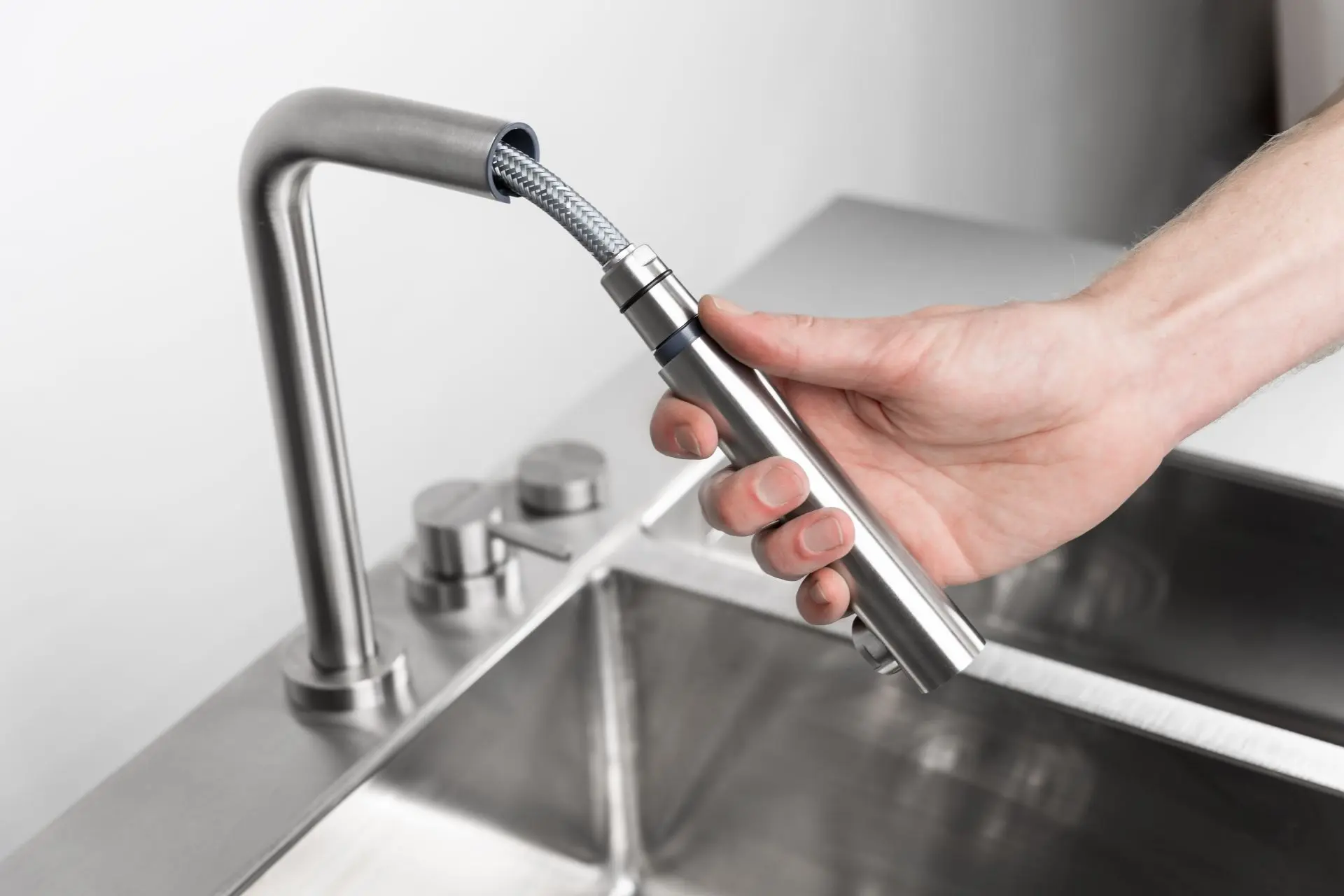 Zoom sur le robinet extractible du module évier Flammkraft Block L, illustrant la fonctionnalité et la qualité des finitions inox.