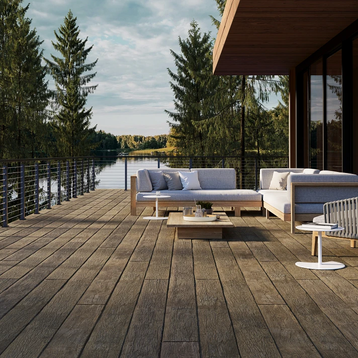 Terrasse surplombant un lac naturel avec des lames Millboard effet bois vintage.