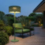 Lampadaire solaire PADERE finition menthe en situation sur terrasse au crépuscule avec fauteuil lounge vert