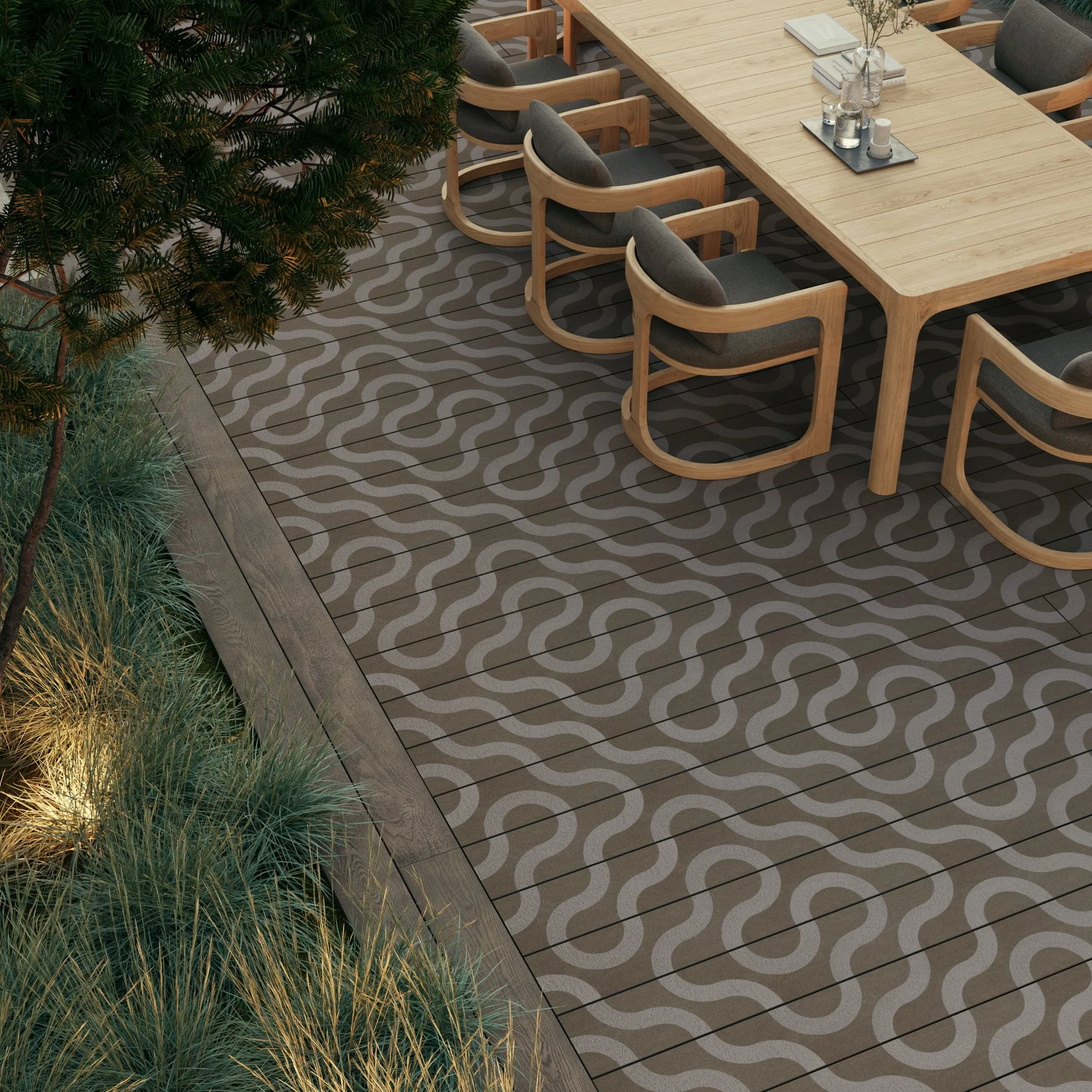 Terrasse de jardin en bois composite foncé à motif ondulé, bordée de plantes et mobilier de salle à manger en bois clair.
