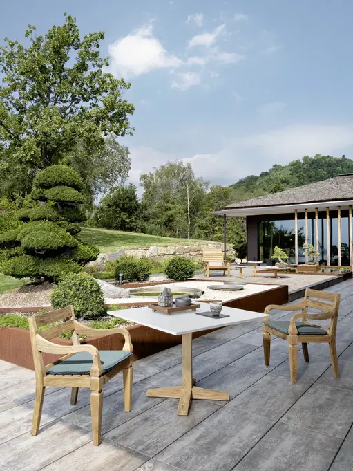 Table JEKO 35 Gervasoni sur terrasse extérieure avec chaises en bois assorties