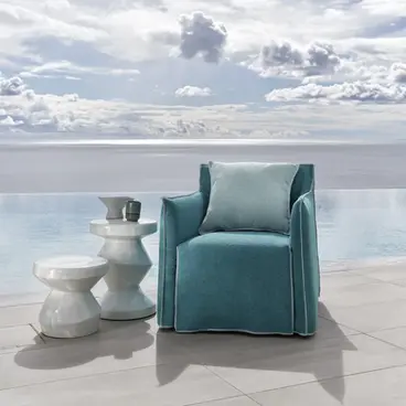 Fauteuil GHOST OUT 05 bleu ciel de Gervasoni en extérieur, face à une piscine et une vue dégagée sur la mer.