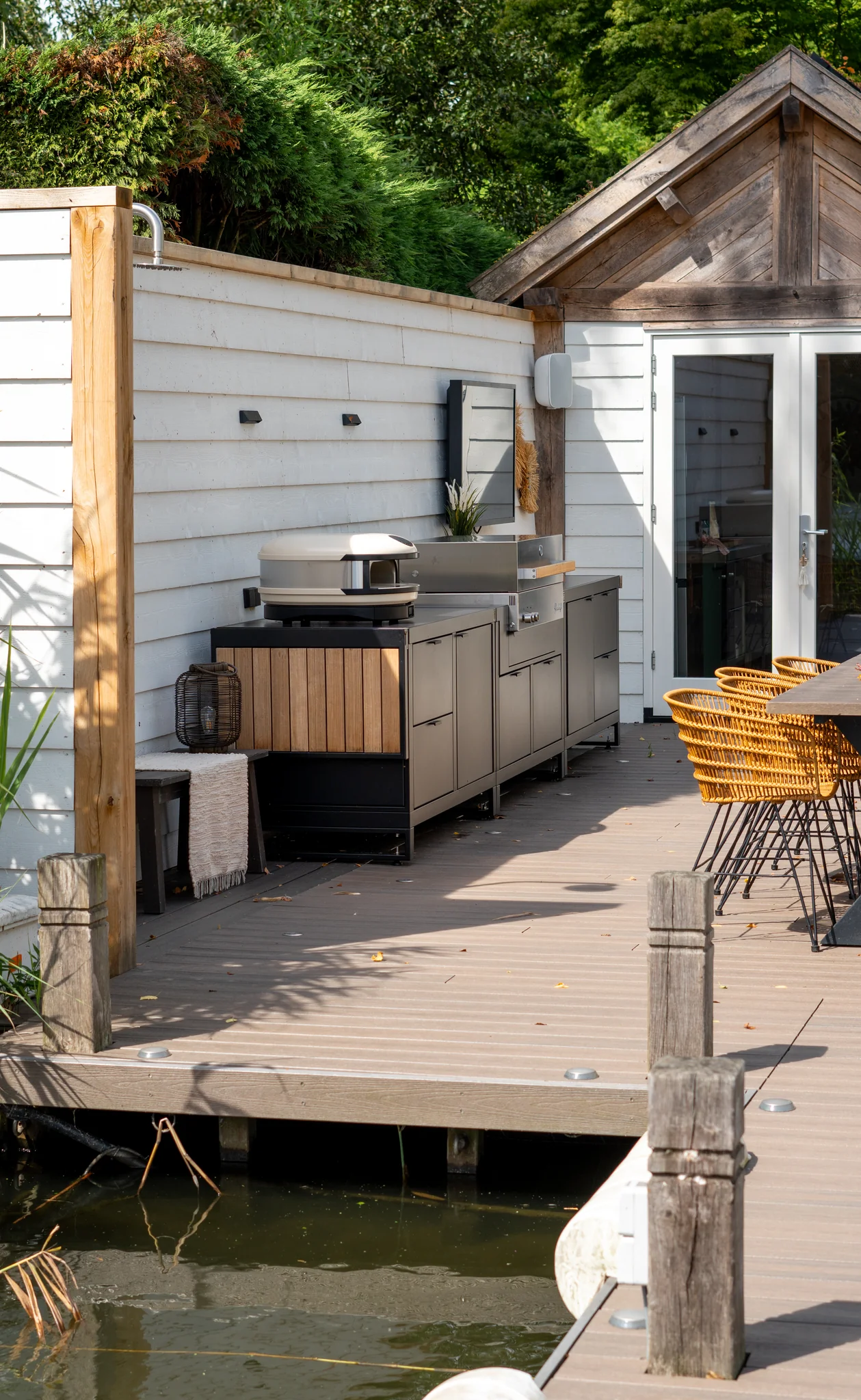 Ensemble Rubix modulaire avec four à pizza et barbecue gaz, plans de travail généreux et rangements, installé sur grande terrasse bois.