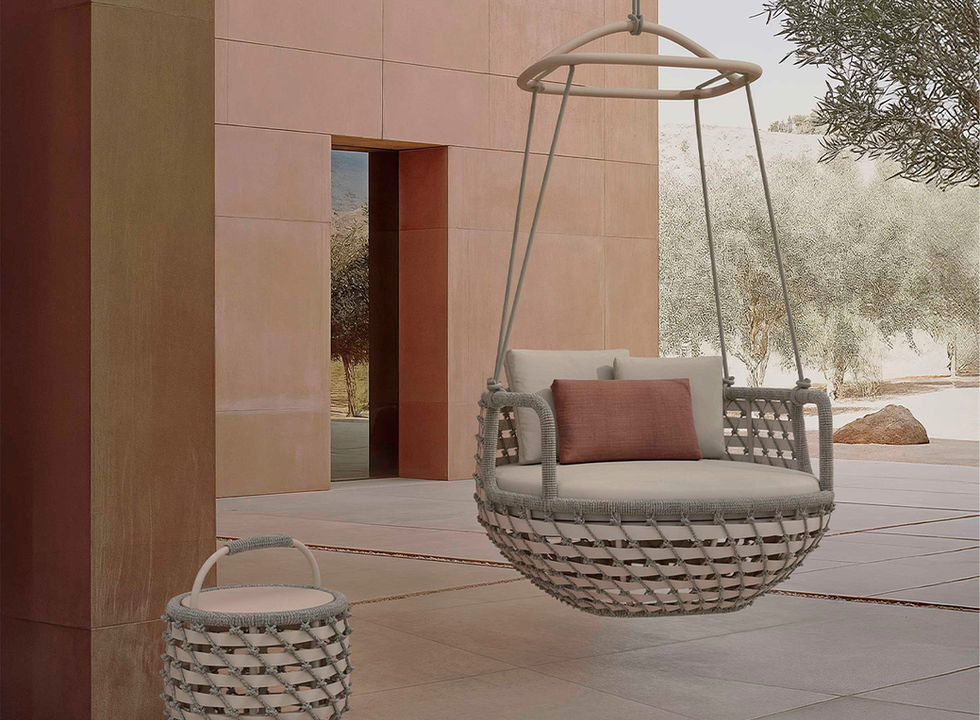 Fauteuil Koro Swing suspendu dans un patio moderne, à côté d’un panier assorti, ambiance douce et méditerranéenne.