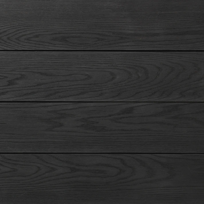 Gros plan sur lames Millboard Enhanced Grain finition Burnt Cedar, aspect bois brûlé contemporain pour terrasses extérieures haut de gamme WAHO