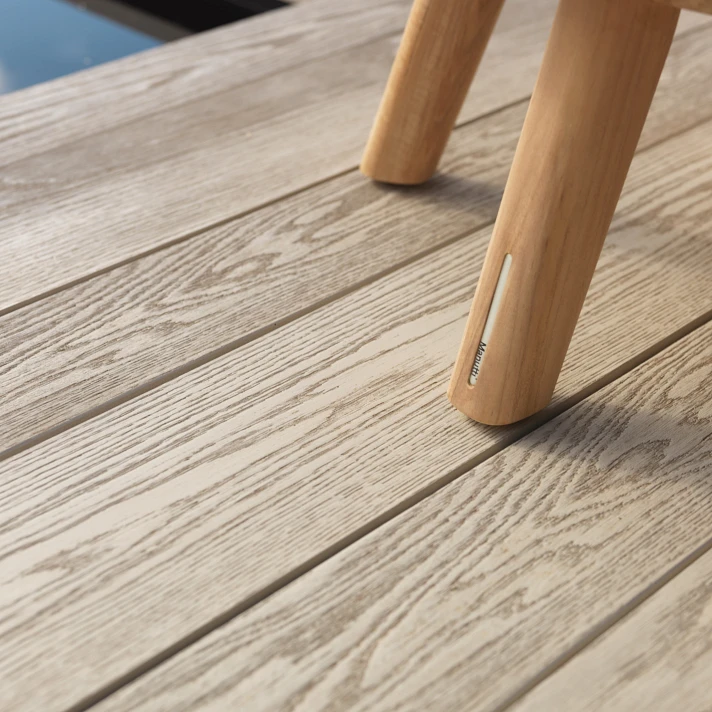 Gros plan sur lames Millboard Smoked Oak et mobilier extérieur en bois clair