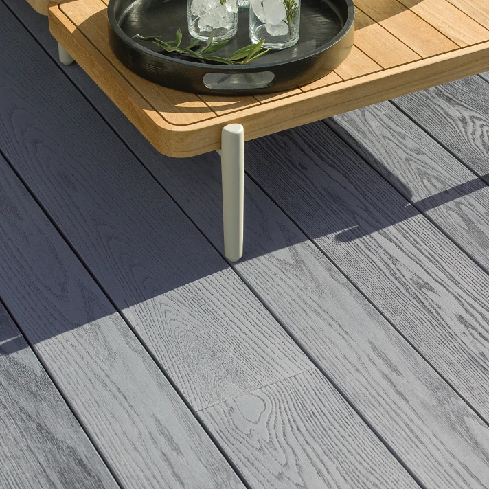 Gros plan sur terrasse Millboard Enhanced Grain coloris gris, parfaite pour un mobilier extérieur moderne.