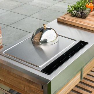 Teppanyaki Indu+ encastré, commande tactile et cloche inox, plan de travail acier avec planche à découper.