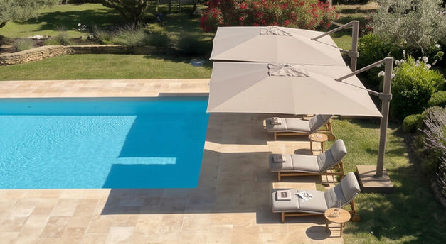 Parasols déportés Talenti ATHENA offrant une protection solaire optimale au-dessus de bains de soleil autour d'une piscine.
