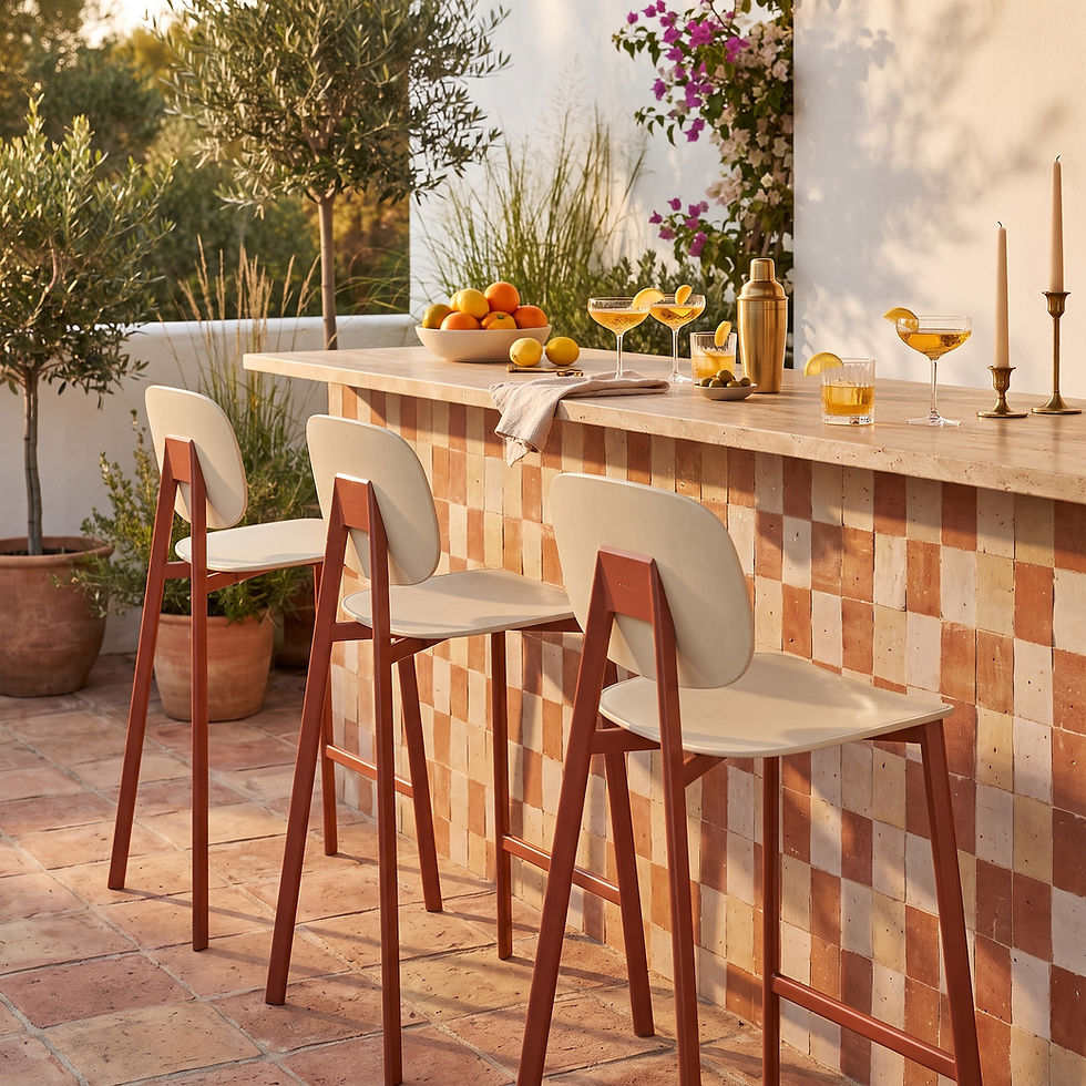 Trois tabourets de bar extérieur TATA Pointhouse, structure rouge brique et assise écru, devant un comptoir en mosaïque terracotta, ambiance golden hour méditerranéenne