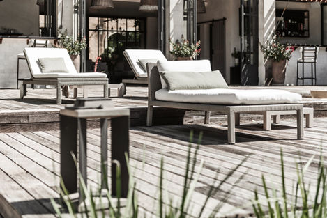 Close-up of comfortable sun loungers on the wooden terrace next to the pool at Mas de Campe, perfect for relaxation