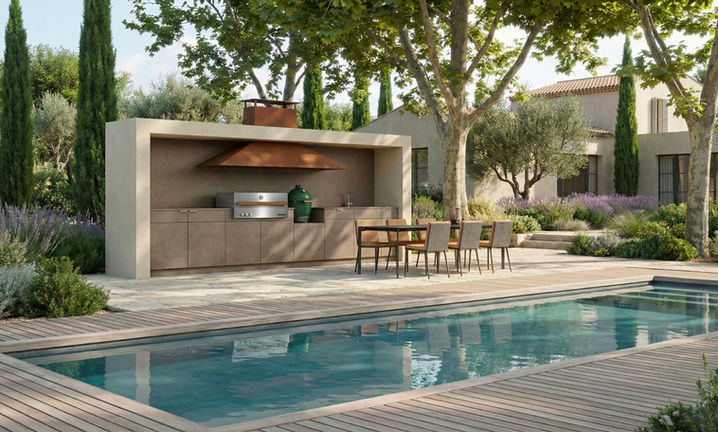 Vue générale de la cuisine extérieure design WAHO à Saint-Cyr-sur-Mer, avec terrasse en pierre, coin repas et piscine au premier plan.