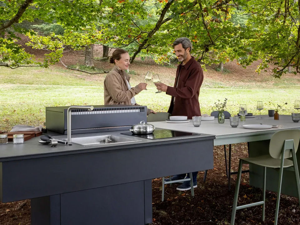 Cuisine extérieure modulable avec plancha, évier et table intégrée, conçue pour des moments conviviaux en extérieur dans un cadre naturel.
