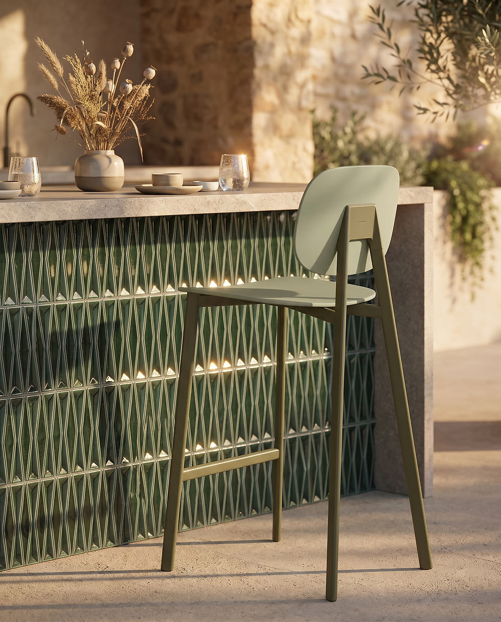 Tabouret TATA Pointhouse finition vert olive et vert sauge devant un comptoir de cuisine extérieure en mosaïque verte, lumière de fin de journée