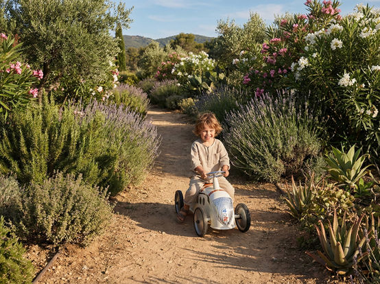 Enfant roulant en voiture à pédales Baghera Rider Peugeot 402 Darl'Mat Beige sur un chemin de campagne