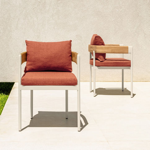 Deux chaises FLOW Talenti avec coussins terracotta et accoudoirs en teck sur terrasse contemporaine