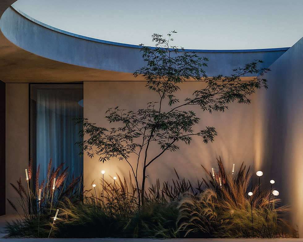 Massif végétalisé en patio éclairé en bain de lumière : piquets lumineux Lodes Reed et petites sphères diffusent une lumière chaude, révélant les textures des graminées et projetant de belles ombres sur le mur.