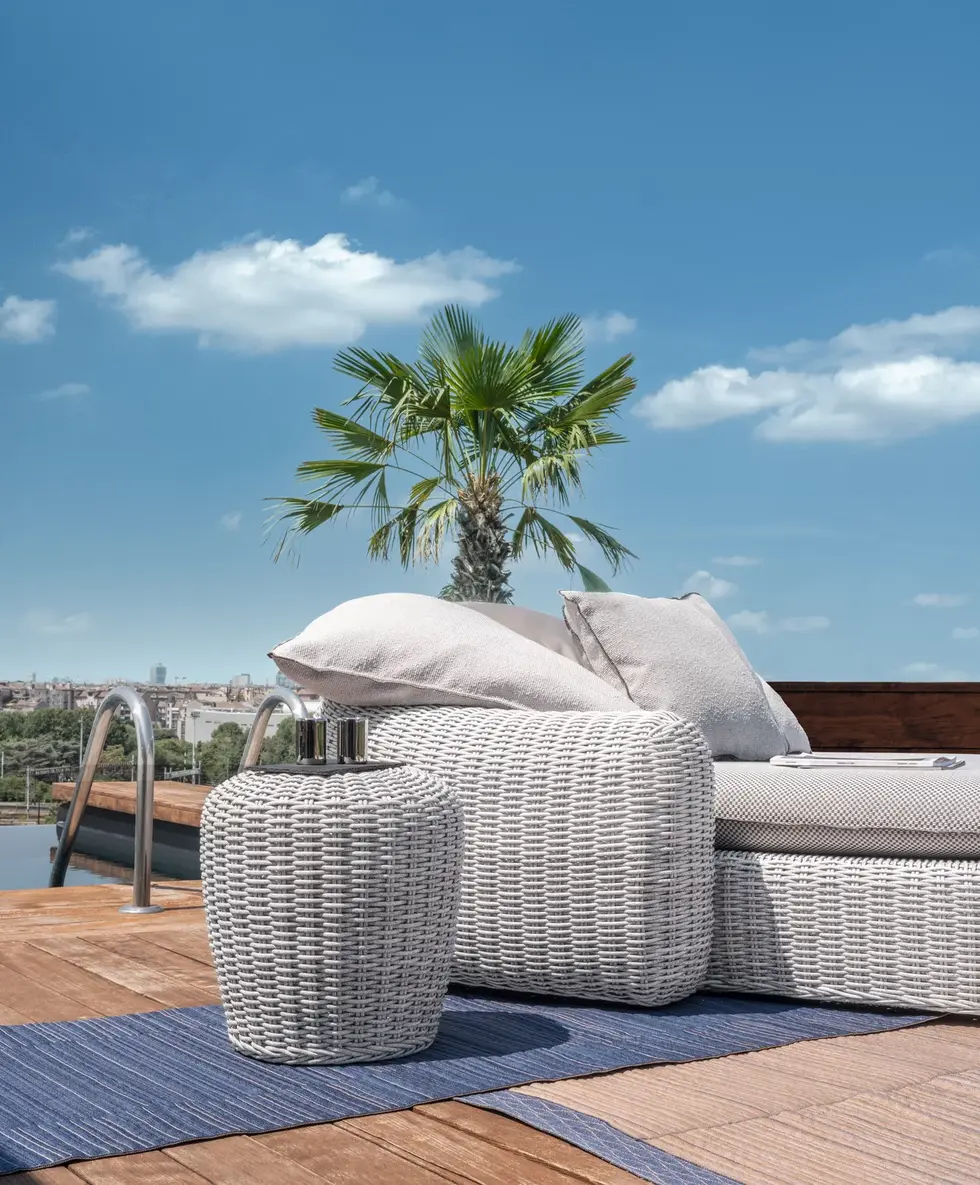 Détail canapé Panda Gervasoni avec pouf assorti sur terrasse rooftop avec vue