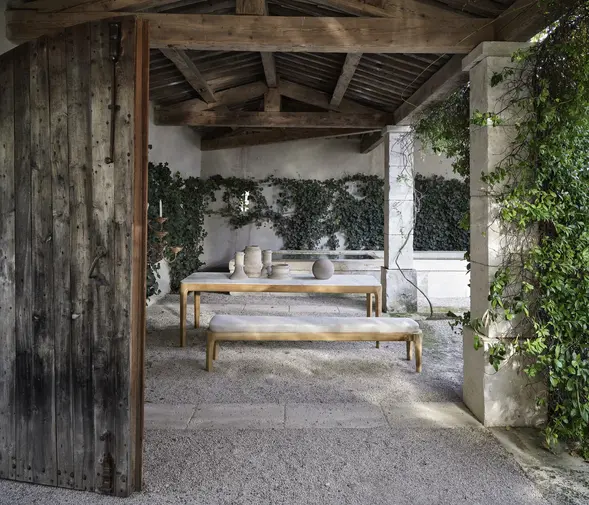 Vue d’ensemble de la table et des bancs MEDITERRANEO dans un espace couvert naturel