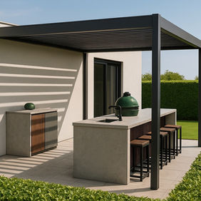 Vue d’ensemble de la cuisine extérieure sur-mesure WAHO à Genève : îlot en grès cérame sous pergola bioclimatique, barbecue Big Green Egg vert et tabourets hauts face au jardin paysager.