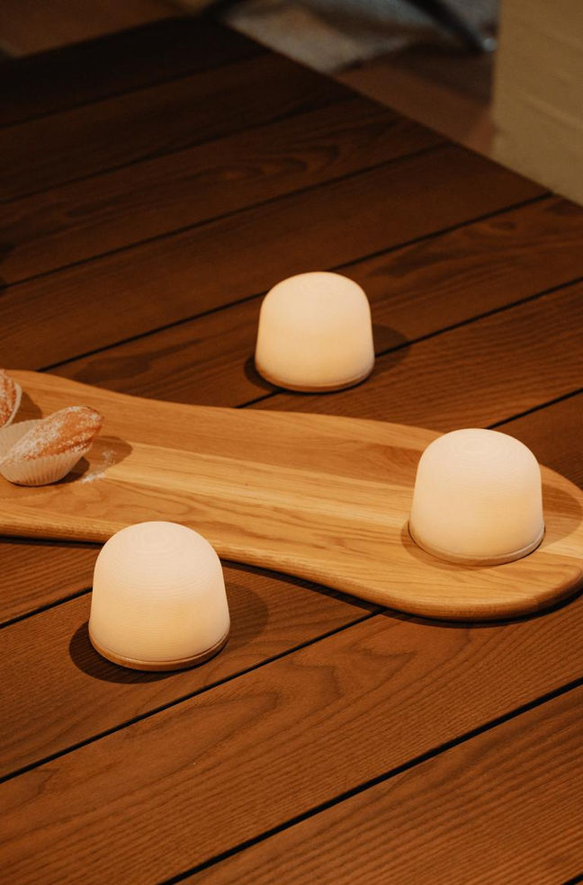 Plateau FONDANT en bois clair sur une table en bois, mis en valeur avec plusieurs lampes LED en forme de dôme.