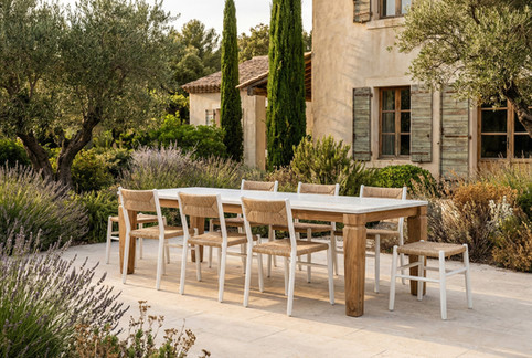 Chaises et tabourets STIPA Maiori Design autour d’une table extérieure dans un jardin méditerranéen