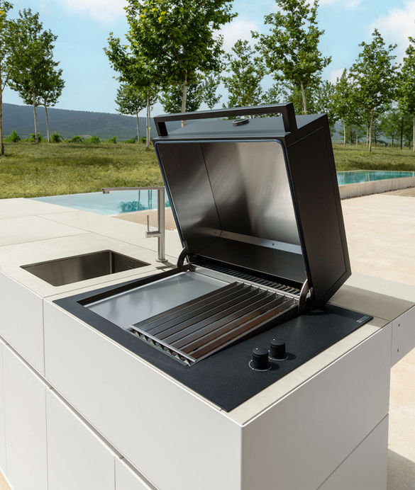 Cuisine extérieure Tikal blanche avec barbecue à couvercle ouvert et évier intégré, vue sur piscine.