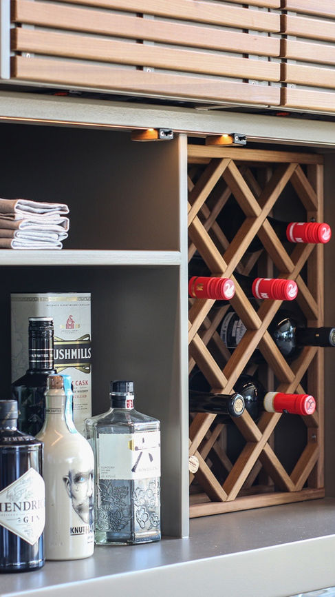 Intérieur du bar dans une armoire Cubic Outdoor Living avec cave à vin en bois, rangements pour verres et bouteilles, illustrant un bar nomade haut de gamme installé par WAHO.