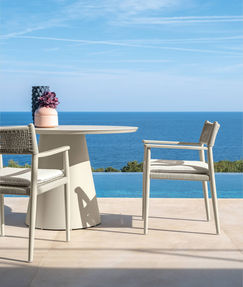 Mobilier d’extérieur en aluminium blanc de la collection DOLCEVITA ALU de Talenti, table ronde et chaises avec vue panoramique sur la mer Méditerranée.