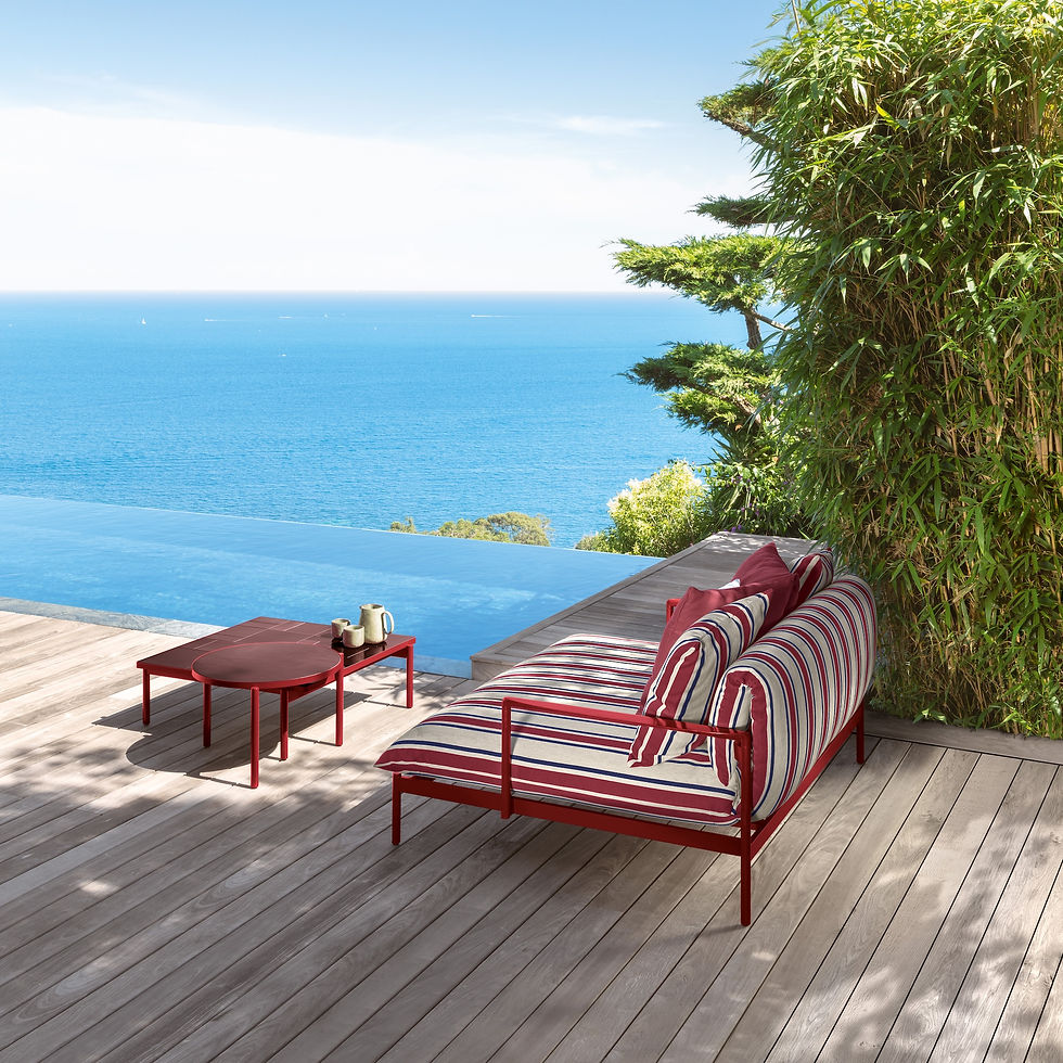Fauteuil de jardin moderne en aluminium rouge et tissu outdoor rayé, idéal pour une terrasse avec vue sur la mer.