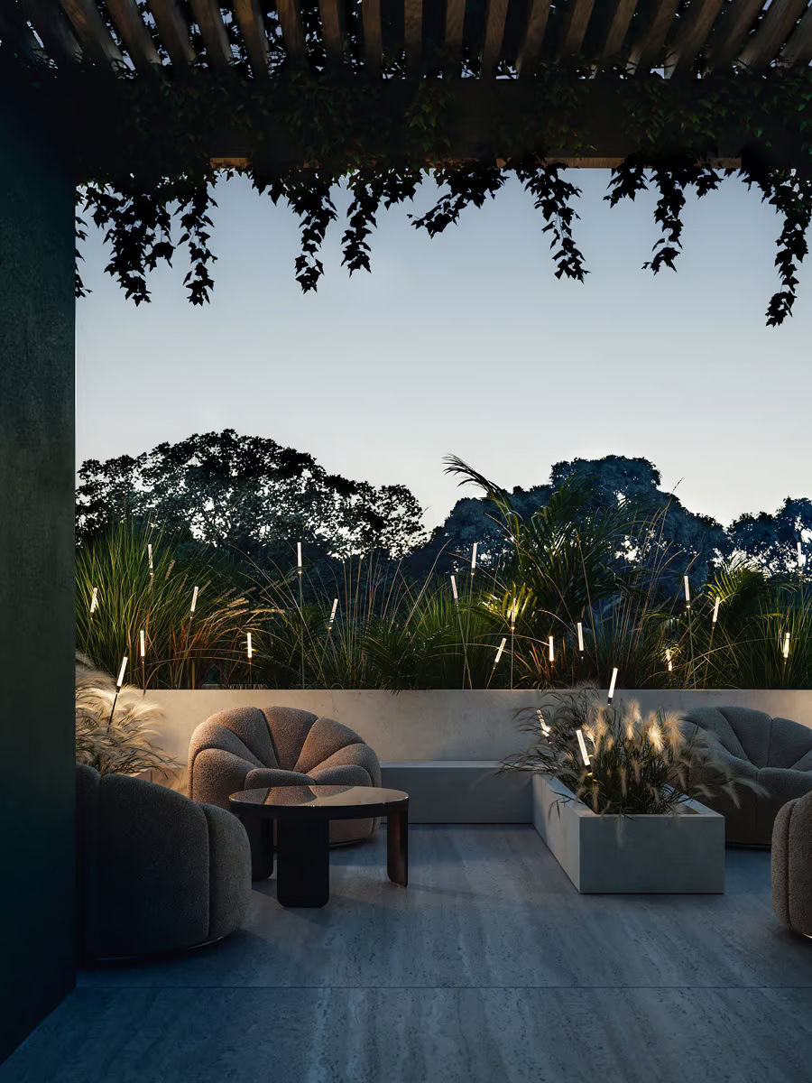 Terrasse au crépuscule avec tiges lumineuses Lodes Reed plantées dans les graminées, créant un halo graphique autour du salon outdoor – design & performance WAHO.