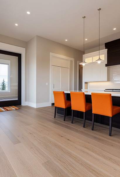 Modern kitchen and living area with light wood flooring, showcasing a clean residential interior and professionally installed wood-look floors.