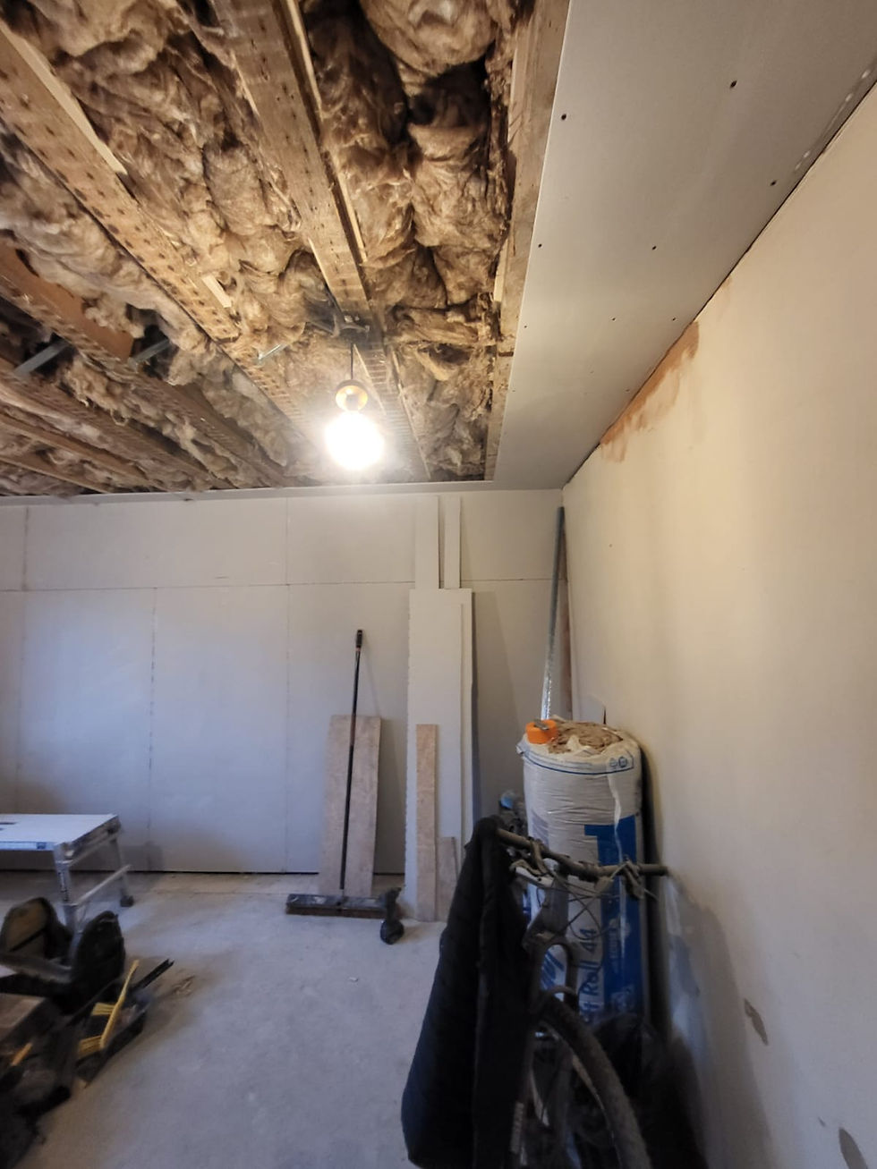 Dry lining the wall with plasterboard and the ceiling 