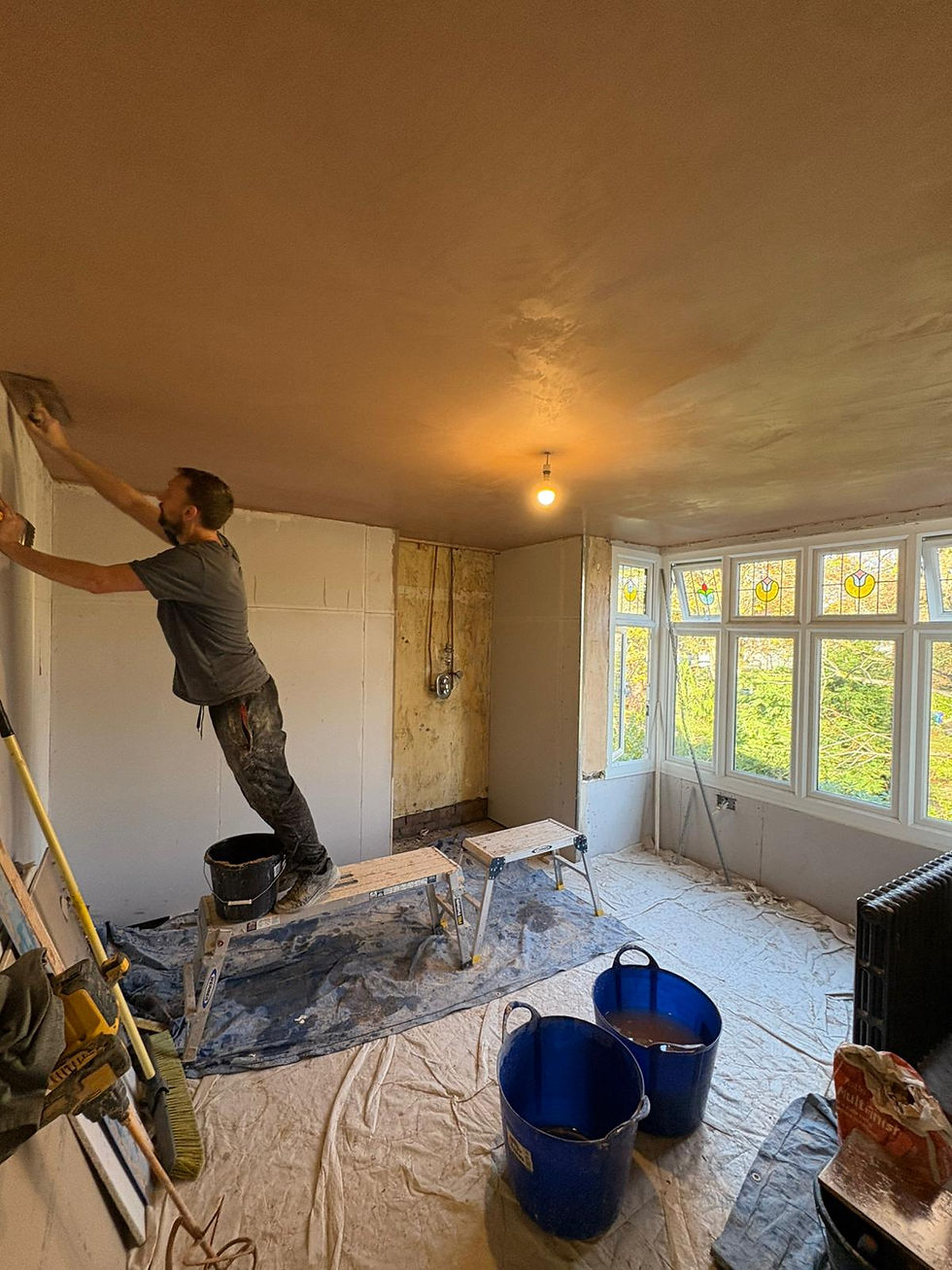 Close-up view of plasterer applying finishing coat on interior wall