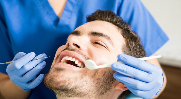 mid-adult-patient-receiving-dental-treatment-with-tools-from-female-dentist-clinic.jpg
