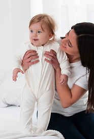 happy-mother-holding-baby-bed.jpg