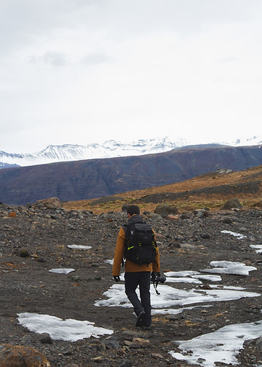 vertical-picture-hiker-with-camera-hills-covered-snow-iceland.jpg