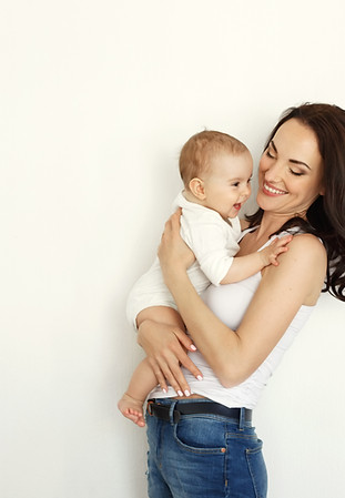 young-happy-mother-smiling-holding-looking-her-baby-daughter-white-wall.jpg