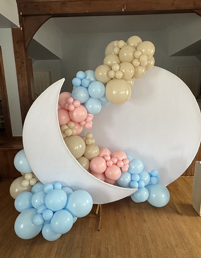 A beautiful balloon garland with a moon backdrop for a baby shower that has the theme twinkle little star