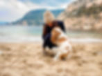 Une femme avec un chien sur la plage en vacances