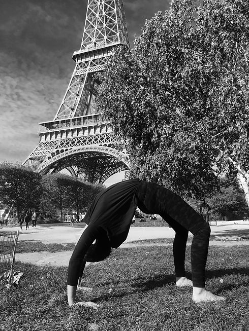 Tara Duffy in Urdhva Dhanurasana (Bridge Pose) in front of the Eiffel Tower, Paris (in black and white).