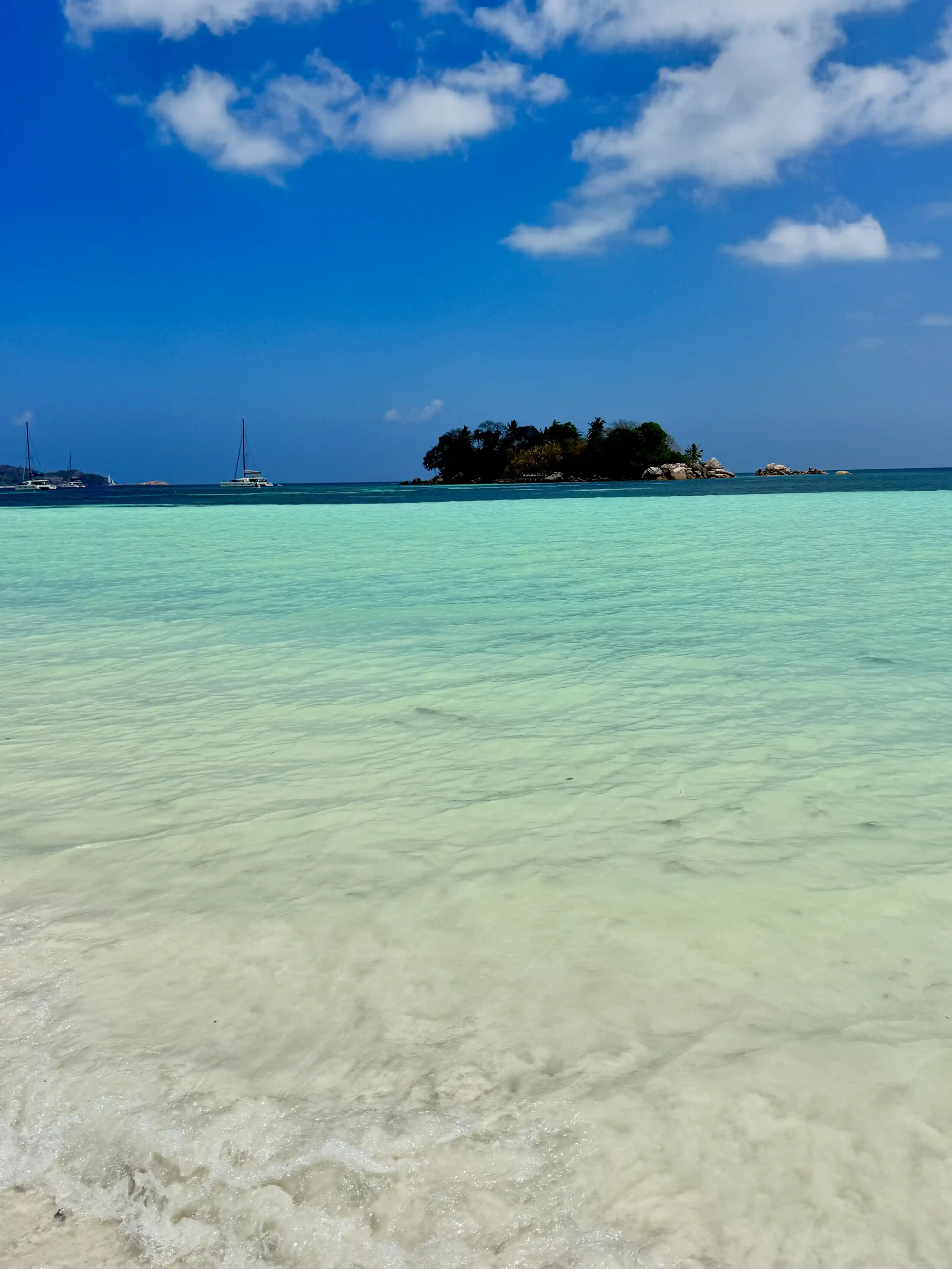 Lagon turquoise et îlot depuis plage Praslin Seychelles