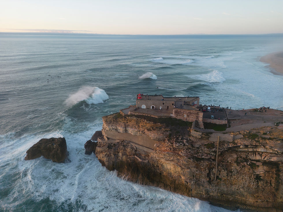 Vista geral das ondas quebrando na Praia do Norte, com o farol em primeiro plano, em Nazaré, Portugal, 2023 – Ricardo Bravo / Red Bull Content Pool