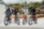 Group of friends smiling with their mountain bikes, ready to explore.