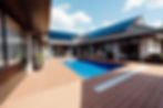 Modern poolside with solar panels on house roof and wooden decking