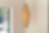 Elegant hanging wooden lamp casting a warm, patterned light on a neutral wall.