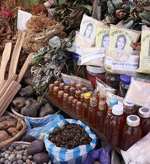 Traditional herbal medicine market stall with oils and herbs