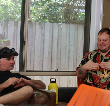 Two peer workers sitting on a couch talking to each other.