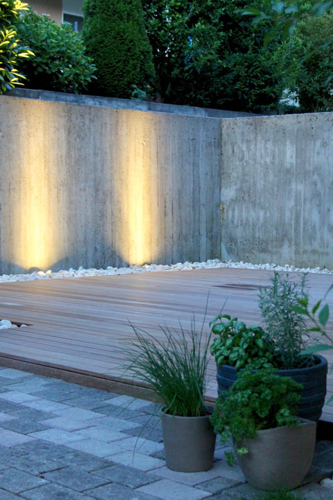 Beleuchtete Holzterrasse mit Pflanzen